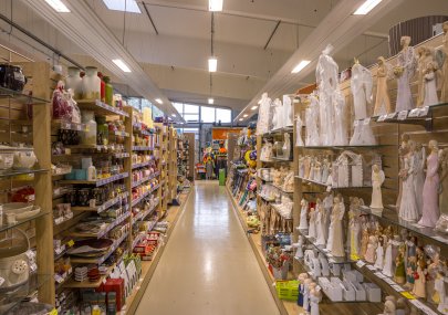 Oddělení bytových doplňků s regály porcelánu, svícnů a dekorativních figurek
