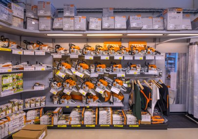 Regál s motorovými pilami STIHL a pracovními oděvy